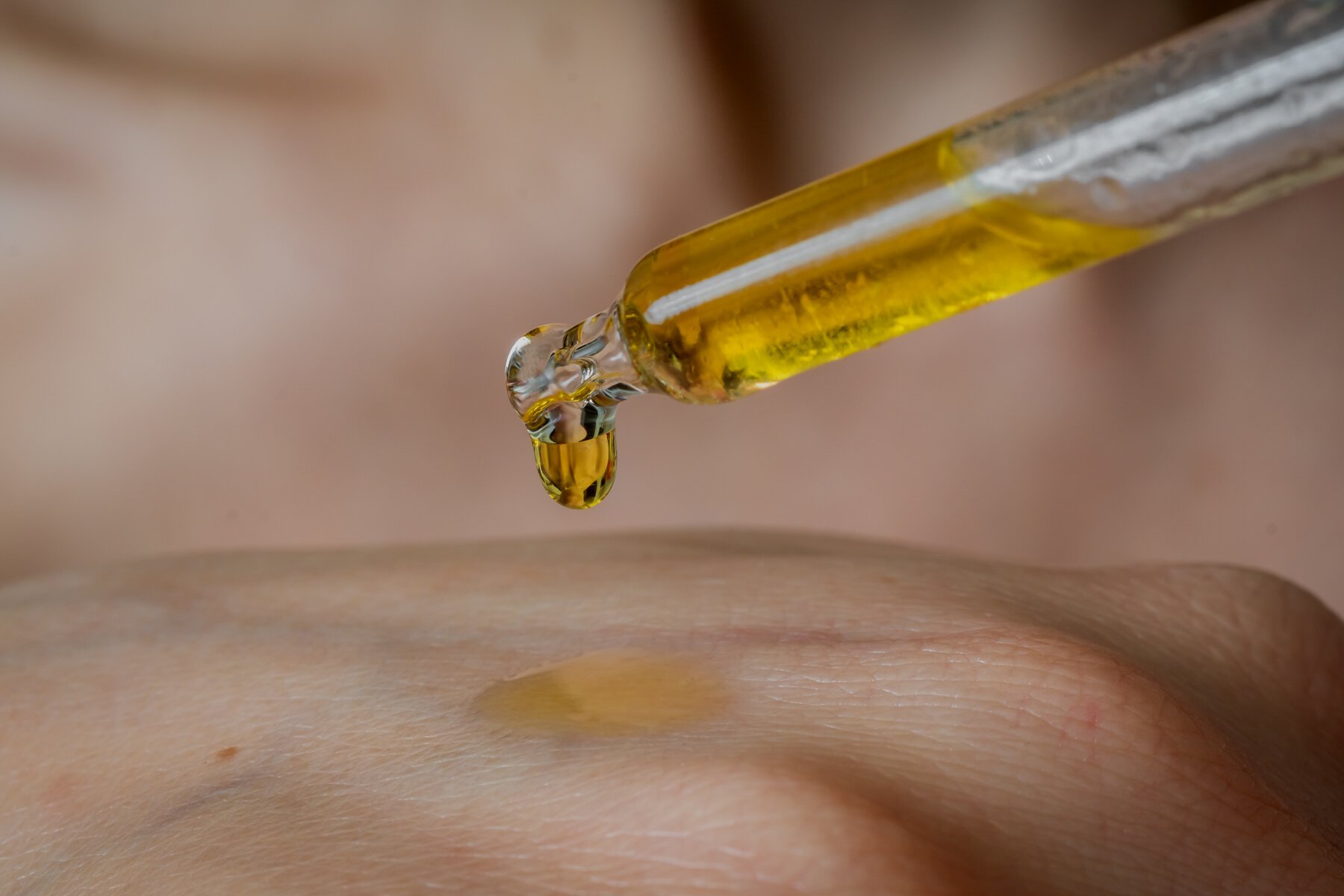 Woman is applying moisturizing body oil on her arm