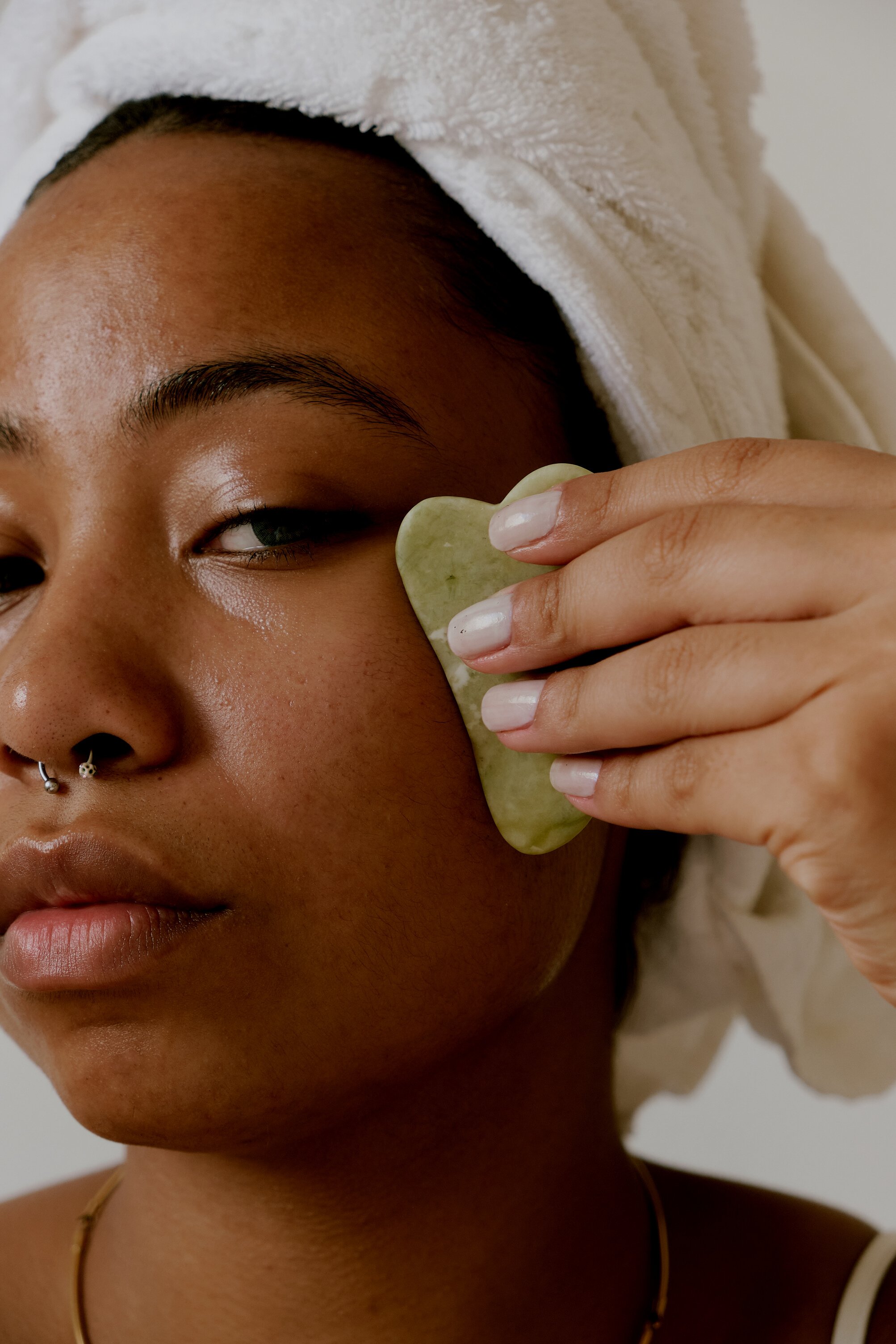 Woman Using a Jade Gua Sha on Face